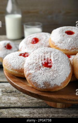 Présentoir à pâtisseries avec de délicieux beignets en gelée sur une table en bois Banque D'Images