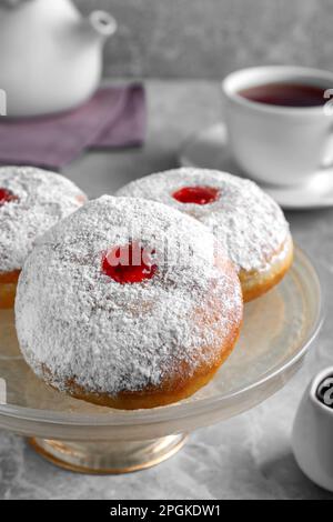 Présentoir à pâtisseries avec de délicieux beignets en gelée sur table grise, en gros plan Banque D'Images