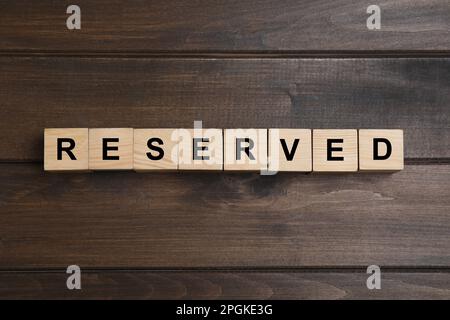 Mot RÉSERVÉ fait avec des cubes sur une surface en bois, vue de dessus. Elément de réglage de la table Banque D'Images