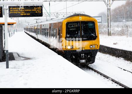 Un train des West Midlands dessert un service de passagers sur une plate-forme enneigée de la gare de Duddeston, près de Birmingham, avec de fortes chutes de neige causant des perturbations dans les transports Banque D'Images