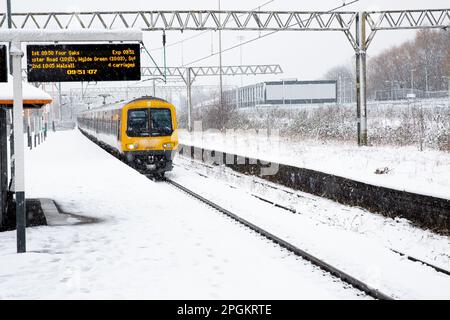 Un train des West Midlands dessert un service de passagers sur une plate-forme enneigée de la gare de Duddeston, près de Birmingham, avec de fortes chutes de neige causant des perturbations dans les transports Banque D'Images