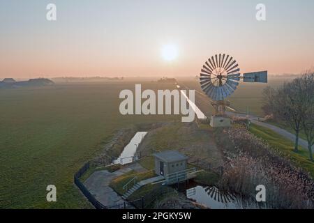 Prise d'un moulin à vent américain dans la campagne depuis Friesland aux pays-Bas au coucher du soleil Banque D'Images