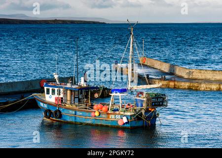 Un bateau de pêche dans le port de John o' Groats à marée haute, Caithness, Écosse, Royaume-Uni Banque D'Images