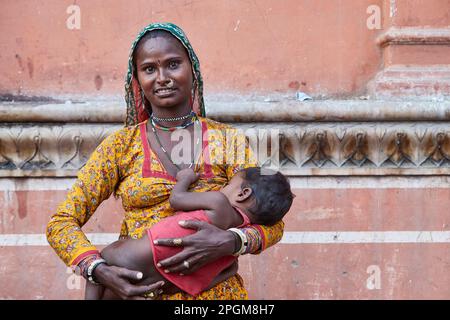 Jaipur, Rajasthan, Inde - Portrait d'une femme indienne tenant son enfant pendant la journée sur la route de Hawa Mahal Banque D'Images