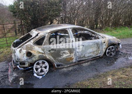 Voiture brûlée sur une route rurale, Cleator Moor, Cumbria, Angleterre, Royaume-Uni Banque D'Images