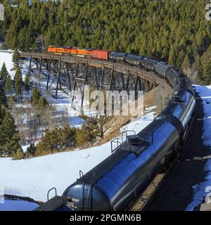 train transportant des voitures à huile au-dessus de la trestle sous mullan pass près d'austin, montana Banque D'Images