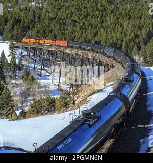 train transportant des voitures à huile au-dessus de la trestle sous mullan pass près d'austin, montana Banque D'Images