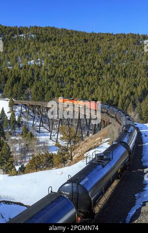 train transportant des voitures à huile au-dessus de la trestle sous mullan pass près d'austin, montana Banque D'Images