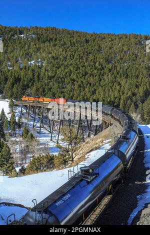 train transportant des voitures à huile au-dessus de la trestle sous mullan pass près d'austin, montana Banque D'Images