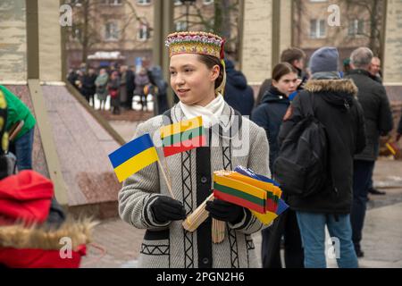 Vilnius Lithuanie - 11 mars 2023 : jolie fille lituanienne en costume traditionnel avec drapeaux lituanien et ukrainien lors d'une cérémonie Banque D'Images