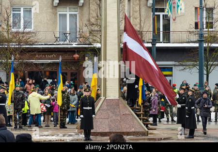 Drapeaux de la Lettonie et de l'Ukraine agitant ensemble lors d'une cérémonie officielle avec des soldats Banque D'Images