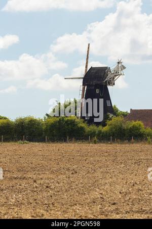 Un ancien moulin à vent anglais traditionnel et maison de ferme cottage niché dans la campagne anglaise de printemps. Banque D'Images