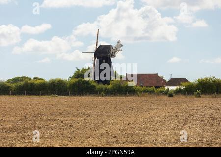 Un ancien moulin à vent anglais traditionnel et maison de ferme cottage niché dans la campagne anglaise de printemps. Banque D'Images