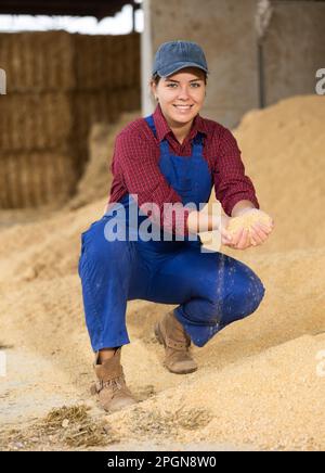 Jeune agriculteur assis sur un tas de cosse de soja Banque D'Images