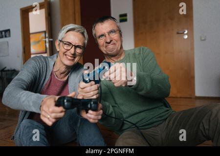 Happy senior couple playing video game at home Banque D'Images