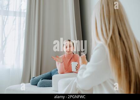 Patient prenant un café et parlant avec un psychologue en clinique Banque D'Images