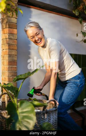 Bonne femme mûre prenant soin des plantes Banque D'Images