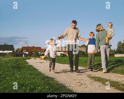 Le père tient les mains de son fils et de sa fille marchant sur le sentier Banque D'Images