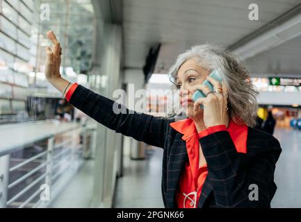 Femme d'affaires frustrée parlant sur un téléphone intelligent à la station Banque D'Images
