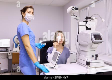 Ophtalmologiste effectuant un test de diagnostic de la vision sur le patient à la clinique Banque D'Images