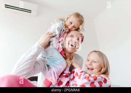 Père heureux appréciant avec les filles à la maison Banque D'Images