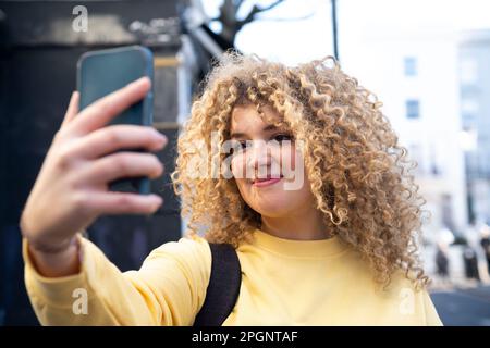 Femme souriante prenant le selfie par smartphone Banque D'Images