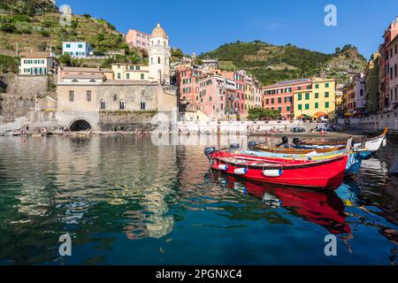 Italie, Ligurie, Vernazza, bord de ville côtière le long de Cinque Terre avec des bateaux amarrés en premier plan Banque D'Images