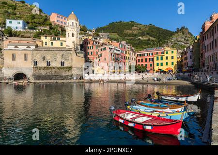 Italie, Ligurie, Vernazza, bord de ville côtière le long de Cinque Terre avec des bateaux amarrés en premier plan Banque D'Images