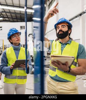Ingénieur gesturant un collègue en usine Banque D'Images