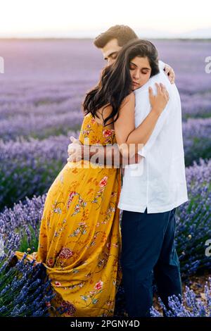 Jeune femme embrassant homme debout au champ de lavande Banque D'Images