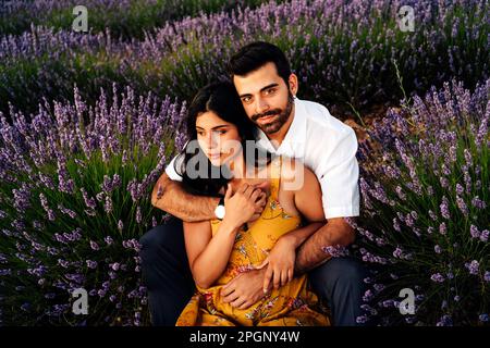 Jeune femme assise avec l'homme dans le champ de lavande Banque D'Images