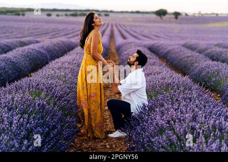 Homme proposant une femme debout dans le champ de lavande Banque D'Images