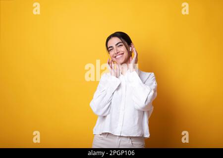 Bonne femme à porter des écouteurs intra-auriculaires sans fil pour écouter de la musique Banque D'Images