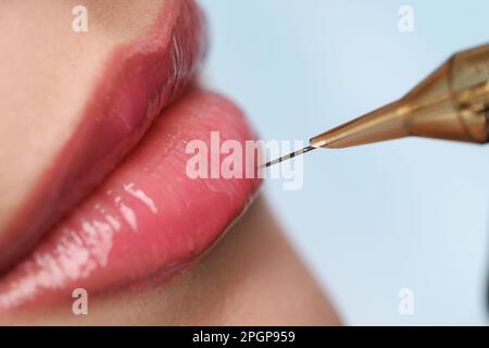 Jeune femme pendant la procédure de maquillage permanent de lèvre dans le salon de beauté, gros plan Banque D'Images