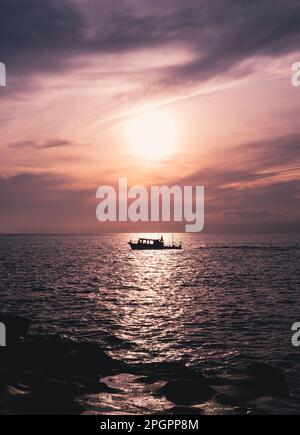 Magnifique coucher de soleil sur l'île d'Enoshima avec une silhouette de yacht à Kanagawa, Japon Banque D'Images