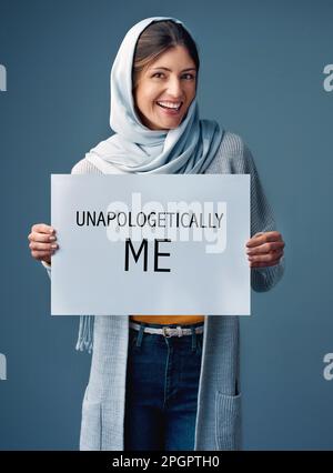 Je ne m'excuse jamais d'être moi-même. Studio portrait d'une jeune femme attrayante tenant un signe lisant SANS EXCUSES MOI contre un gris Banque D'Images