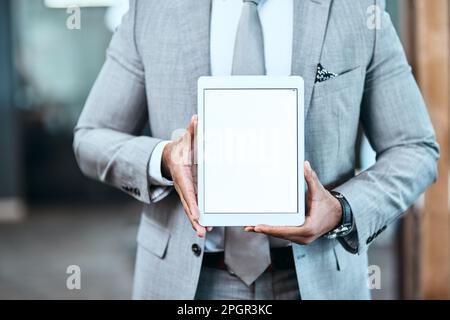 Passer en ligne signifie aller plus loin. Gros plan d'un homme d'affaires méconnu tenant une tablette numérique avec un écran vierge dans un bureau. Banque D'Images