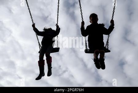 AUTORISATION ACCORDÉE. Photo du dossier datée du 04/03/2017 d'enfants qui jouent sur des balançoires dans un parc près d'Ashford, dans le Kent. Un fonds de £50 millions a été alloué pour réorganiser les parcs de jeu dans toute l'Écosse par le gouvernement écossais. La ministre des enfants, Clare Haughey, a dévoilé ce financement lors d'une visite au parc Figgate à Édimbourg, aux côtés des élèves de l'école primaire de Duddingston, jeudi. L'argent, qui fait partie des £60 millions prévus dans le Programme pour le gouvernement, sera distribué aux conseils jusqu'à la fin du mandat parlementaire en 2026. Date de publication : vendredi 24 mars 2023. Banque D'Images