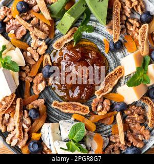 divers fromages sur une assiette avec des noix et des confits. mélanger sur une assiette. Alimentation saine, gros plan. Il sert de la nourriture dans un restaurant Banque D'Images