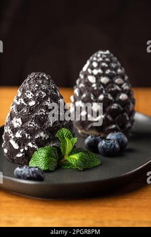 Mini-mousse dessert sous forme de cône de pin, recouvert de velours. Gâteau européen moderne. Cuisine française. Ambiance de Noël Banque D'Images