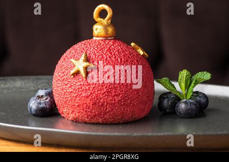 Mini-mousse dessert sous forme de jouet, recouvert de velor ou glacé. Gâteau européen moderne. Cuisine française. Ambiance de Noël Banque D'Images