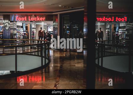 Une photo en façade d'un magasin de Footlocker avec le logo affiché au-dessus de l'entrée. Foot Locker, le détaillant de chaussures basé aux États-Unis, subit une transformation en Asie en vue de simplifier son modèle commercial et de se concentrer sur les régions et les bannières principales. Dans le cadre de cette initiative, foot Locker fermera ses magasins de commerce électronique et de brique et mortier à Hong Kong et Macao, tout en convertissant tous ses magasins actuels et autonomes ainsi que le commerce électronique à Singapour et en Malaisie en un modèle de licence. Les résultats du quatrième trimestre 2022 de foot Locker ont révélé que l'entreprise prend une série d'actions pour diffuser Banque D'Images