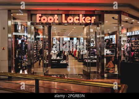 Une photo présente l'extérieur d'un magasin de Footlocker, avec son logo noir et blanc emblématique placé en évidence sur un fond rouge au-dessus de l'entrée. Foot Locker, le détaillant de chaussures basé aux États-Unis, subit une transformation en Asie en vue de simplifier son modèle commercial et de se concentrer sur les régions et les bannières principales. Dans le cadre de cette initiative, foot Locker fermera ses magasins de commerce électronique et de brique et mortier à Hong Kong et Macao, tout en convertissant tous ses magasins actuels et autonomes ainsi que le commerce électronique à Singapour et en Malaisie en un modèle de licence. Le quatrième trimestre 2022 de foot Locker resul Banque D'Images