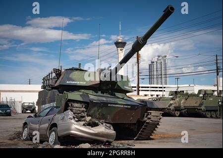 Un char militaire vert se déplaçant dans un paysage, écrasant une voiture sous ses voies Banque D'Images