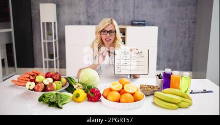 Infirmière diététiste écrivant les objectifs nutritionnels et l'horaire des repas Banque D'Images