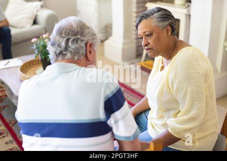 Divers amis âgés assis dans la salle de séjour, parlant pendant la séance de thérapie de groupe. Style de vie, amitié et soutien senior. Banque D'Images