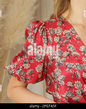 Série de photos de studio de jeune femme modèle en rouge floral soie satin midi robe. Banque D'Images