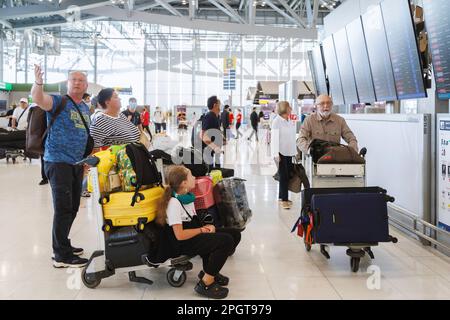 Bangkok, Thaïlande - 19 janvier 2023 : touristes étrangers de famille vérifiant les horaires de vol de départ et d'arrivée à l'aéroport de suvarnabhumi. Banque D'Images