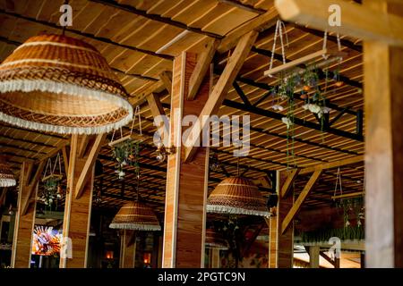 Lampes en osier, toit en bois. Décoration intérieure tendance d'un café hippster dans un style loft. Banque D'Images