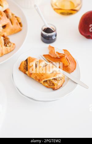 Petits pains à la cannelle et à la pomme sur une table en bois blanc Banque D'Images